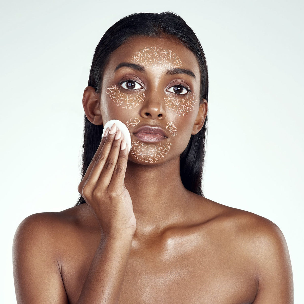 A beautiful woman doing a skincare routine with a diagram on her face representing Psychodermatology.